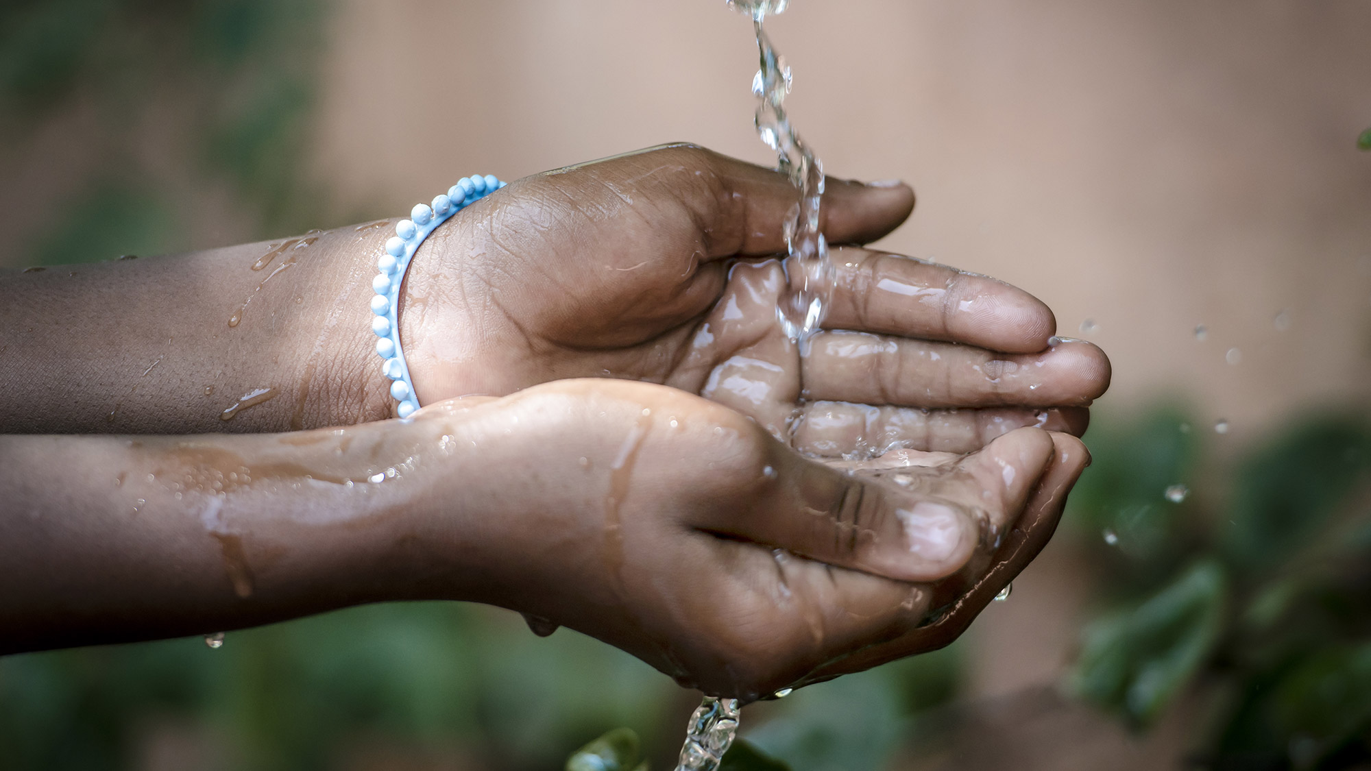 water spilling into black African children hands header